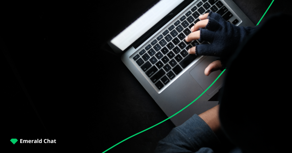 gloved hand typing on laptop keyboard indicating online predator and criminal